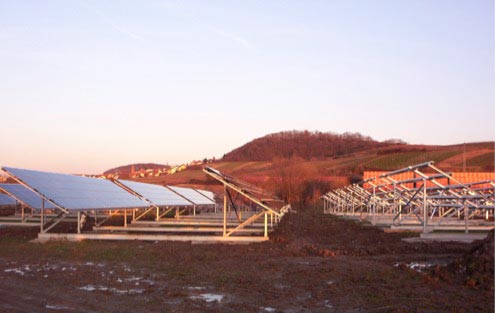  Zu sehen ist die teilweise fertiggestellte Photovoltaikanlage. Auf der linken Seite sind die Solarpanele bereits fertig montiert. Auf der rechten Bildseite ist die noch leere Unterkonstruktion zu sehen.